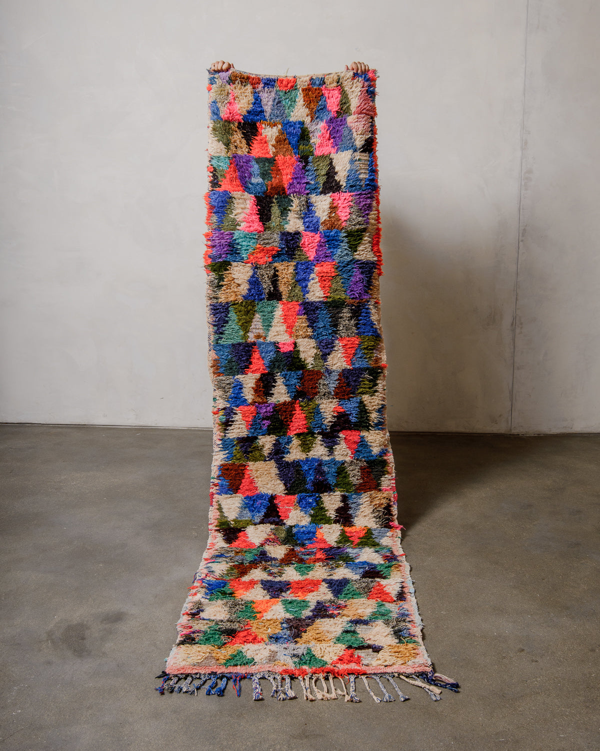 Multicolored geometric patterned rug on a plain background